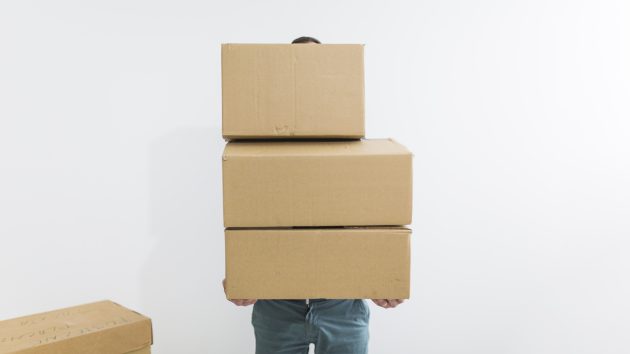 movers guide man holding boxes