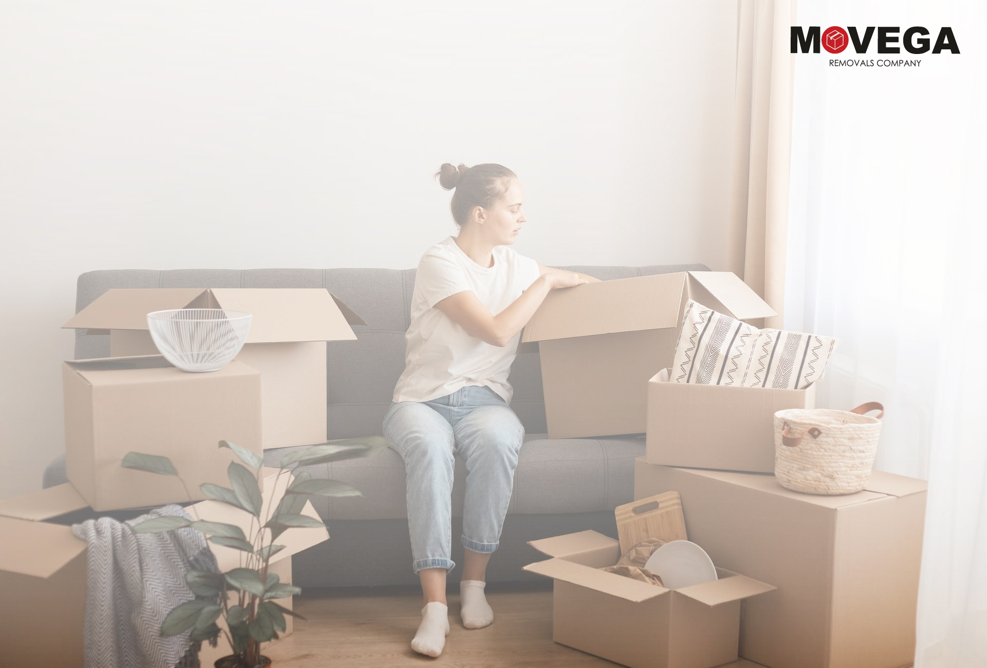 Woman sitting on sofa packing luggage in cardboard boxes